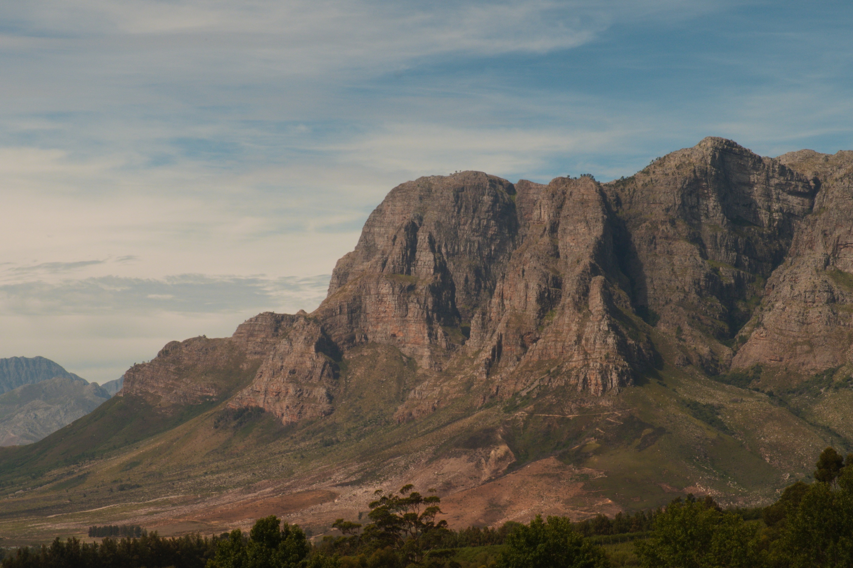 Mountain ridge beneath a broad blue sky