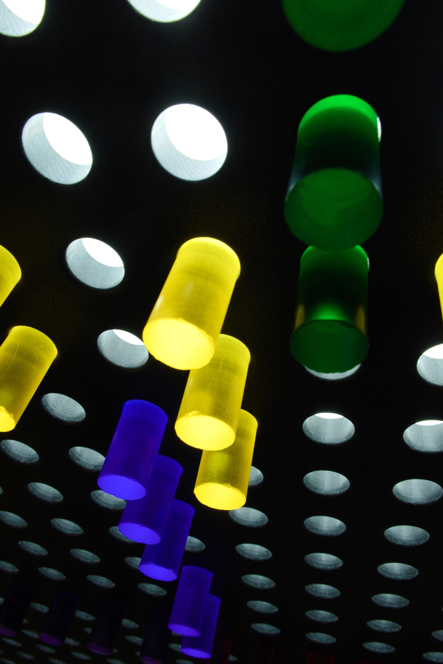 Colored cylinders and circular lights against black