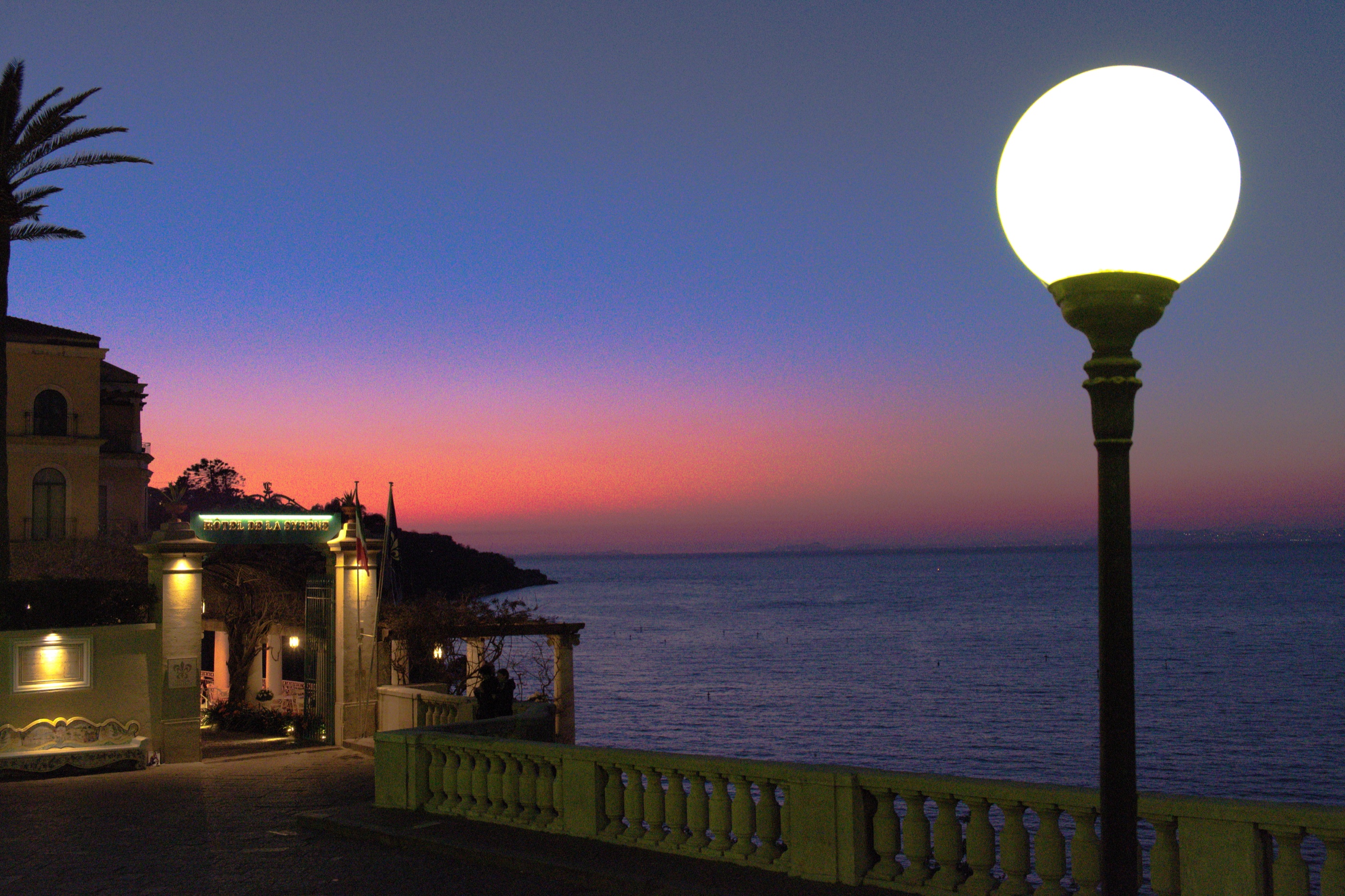 Glowing globe lamp above the sea at dusk